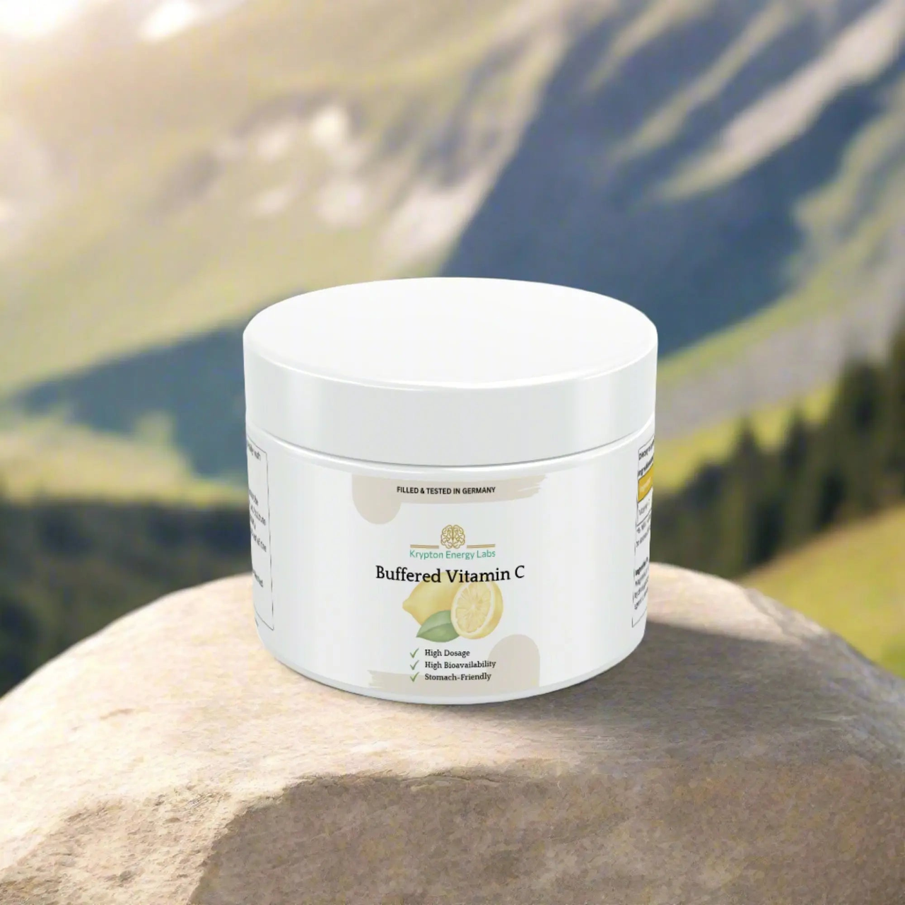 A jar of Buffered Vitamin C from Krypton Energy Labs sits on a rock with a blurred, scenic mountain landscape in the background. The white container clearly indicates it is filled and tested in Germany, boasting high dosage, high bioavailability, and stomach-friendly properties to support your immune system.