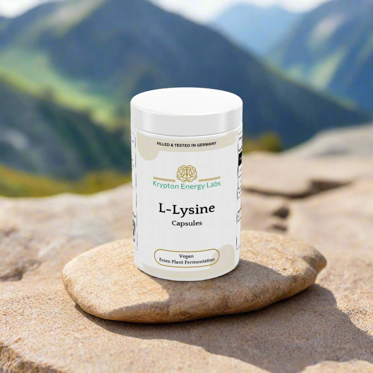 A container of L-Lysin capsules from Krypton Energy Labs is placed on a rock. The label indicates that the capsules are vegan and derived from plant fermentation, supporting immune function and collagen production. The background showcases a mountainous landscape with blurred, green hills and rocky terrain.